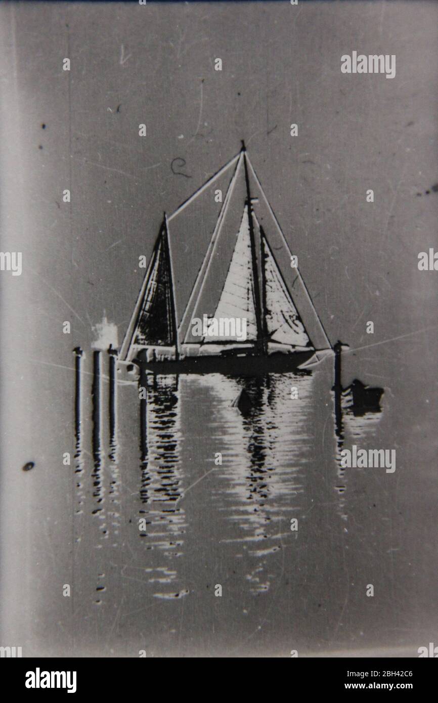 Fine 70s vintage extreme high contrast contact print photography of  a small flotilla of sailboats floating around calm waters Stock Photo