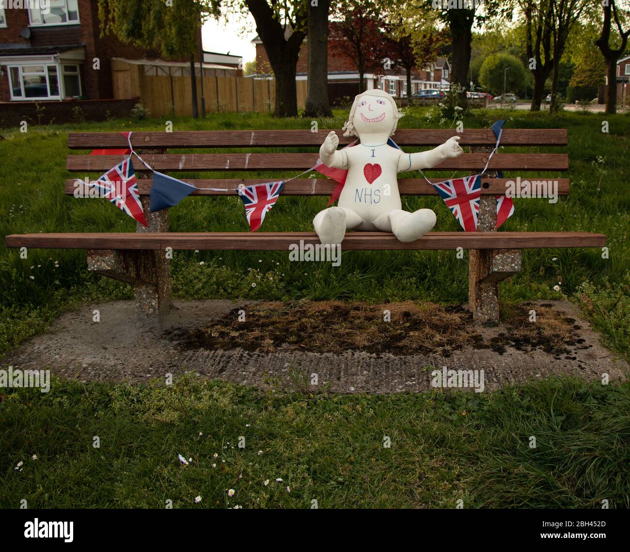A dummy with 'I love NHS' sits on a bench surrounded with flags during the Coronavirus our Covid