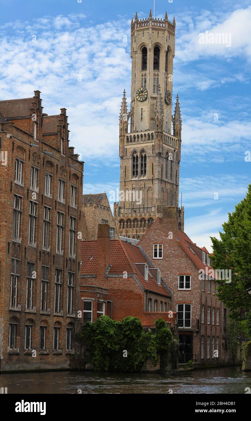 Famous view of Bruges tourist landmark attraction - Rozenhoedkaai canal with Belfry and old houses along canal with tree . Belgium Stock Photo