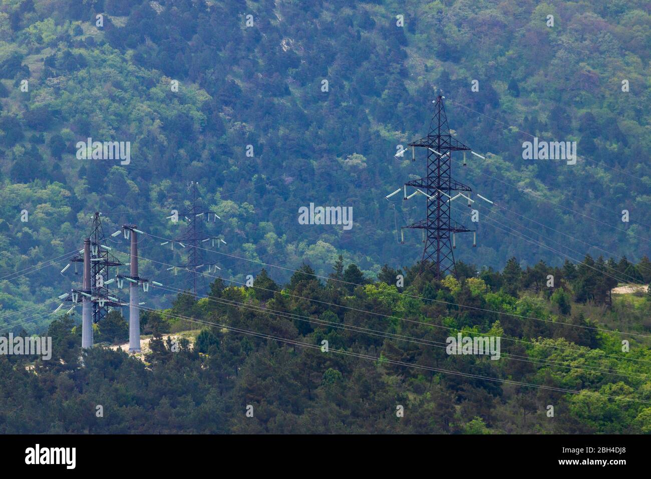 High voltage power lines in mountain forest Stock Photo - Alamy