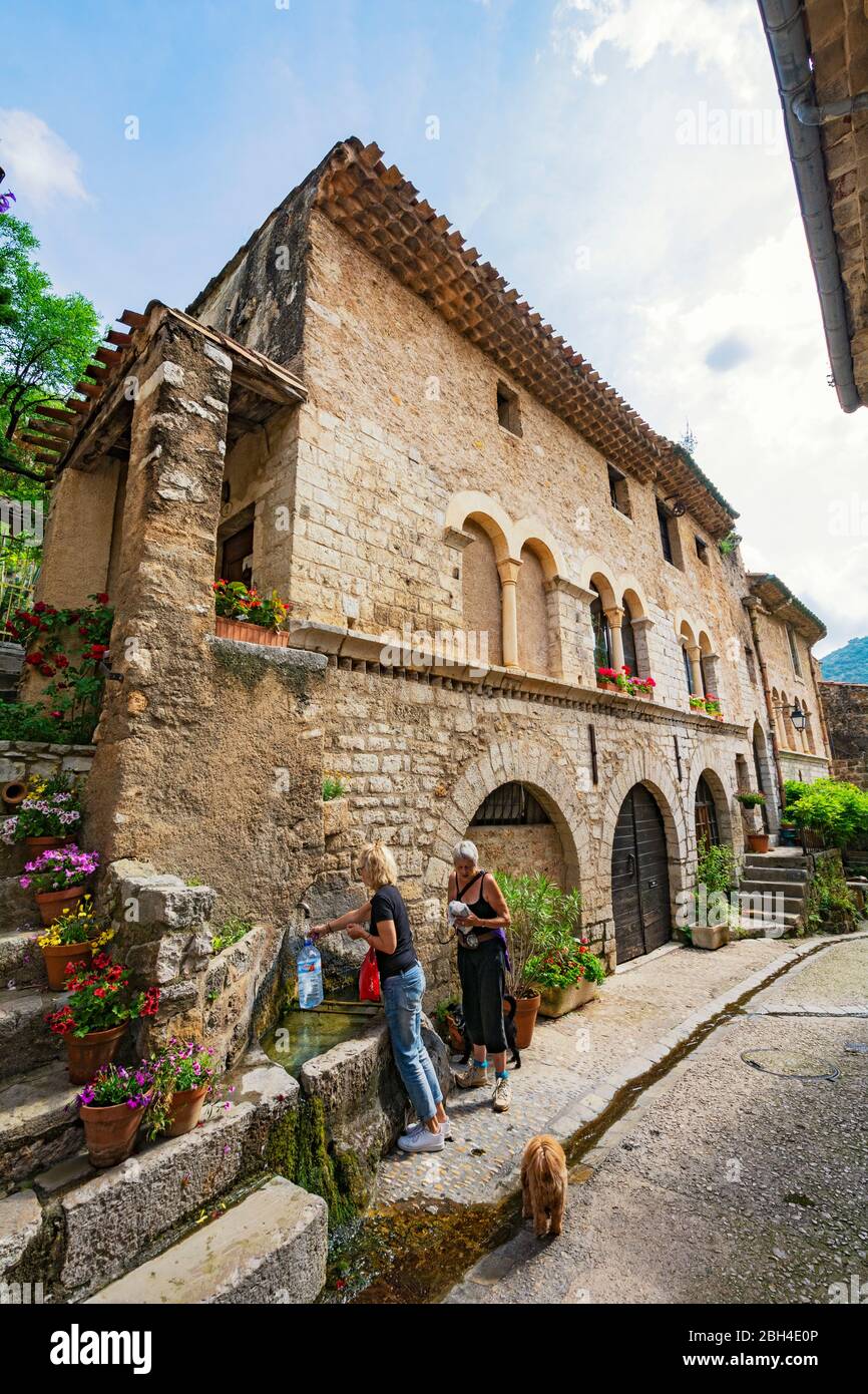 France, SaintGuilhemleDesert, potable water fountain, two women