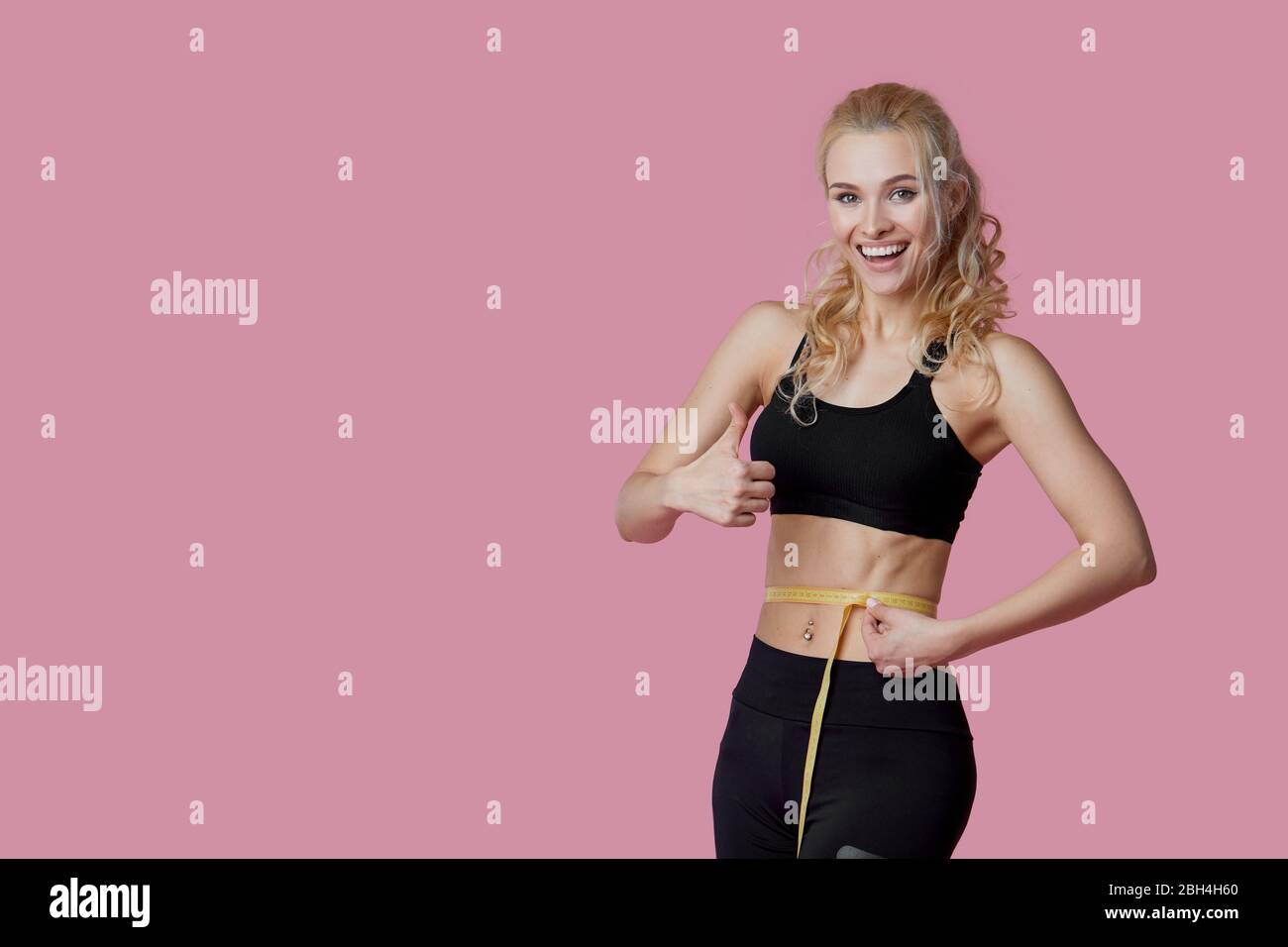 Fitness, workout, healthy lifestyle and diet concept - thin athletes women measure waist after exercise. Quarantine online training Stock Photo