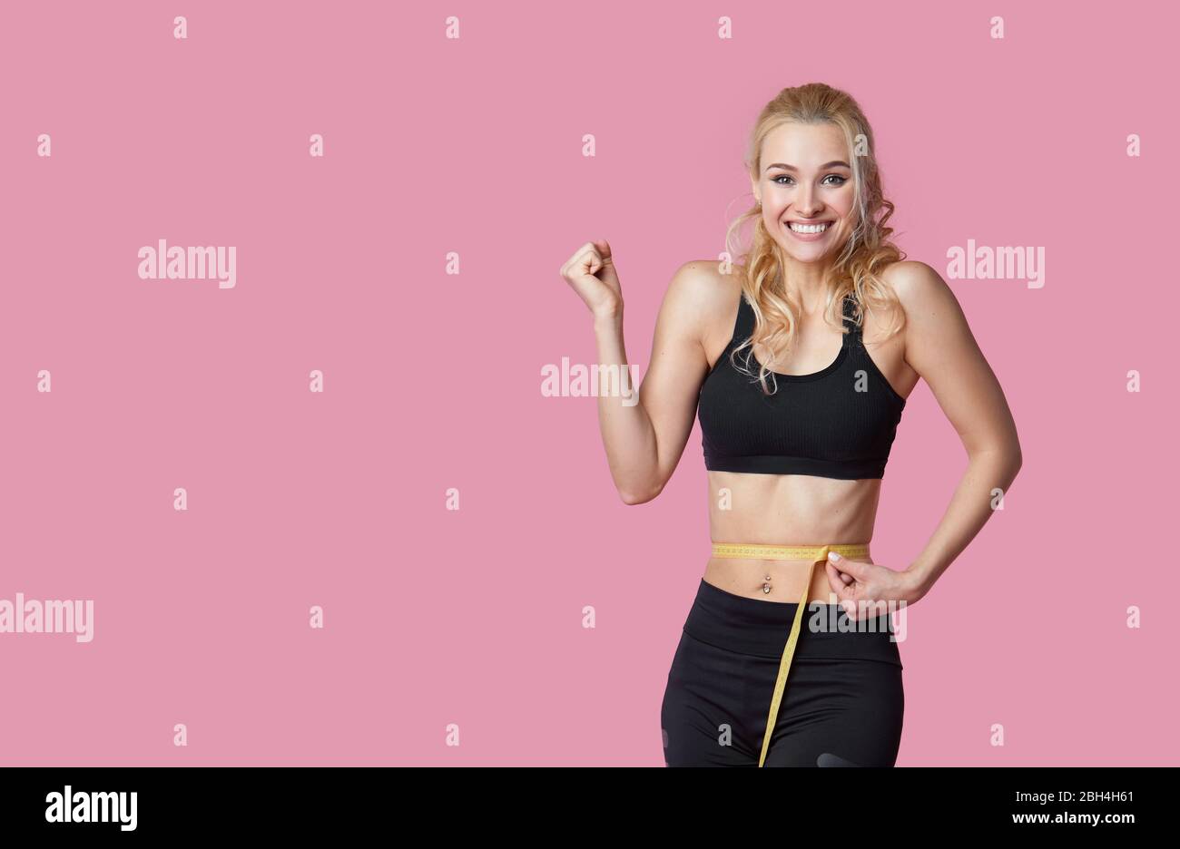 Fitness, workout, healthy lifestyle and diet concept - thin athletes women measure waist after exercise. Quarantine online training Stock Photo