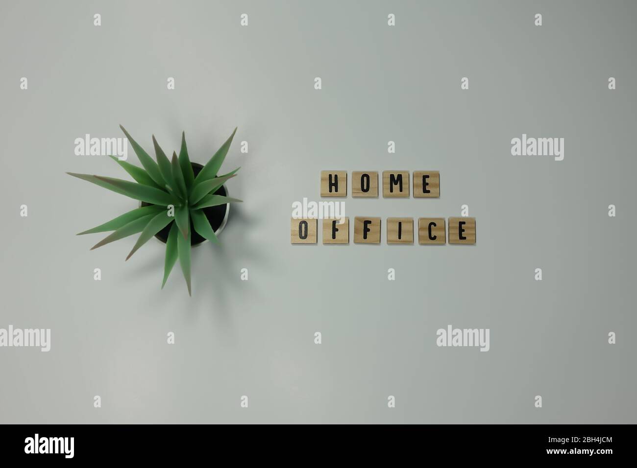 The word home office written in wooden letter tiles on a white background.  Concept work from home, technology, workspace, and lifestyle. Stock Photo
