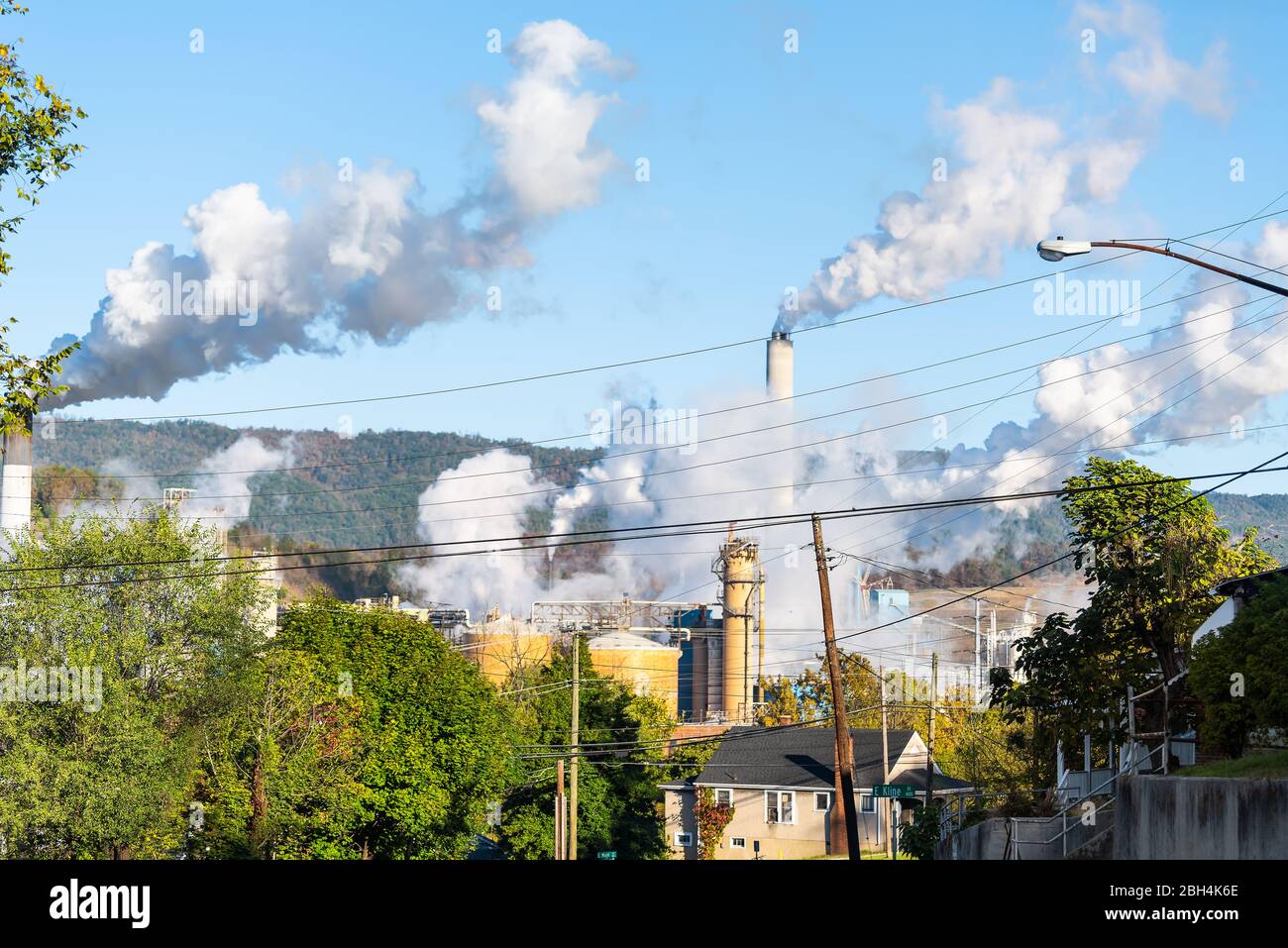 Covington, Virginia city in Alleghany county small town and smog pollution from paper mill smokestack during autumn day Stock Photo