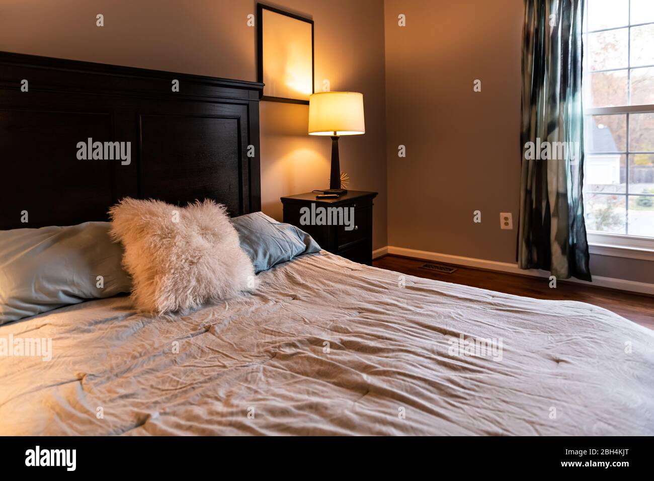 https://c8.alamy.com/comp/2BH4KJT/closeup-of-bed-with-decorative-fluffy-pillow-and-wooden-headboard-in-bedroom-in-staging-home-house-country-style-2BH4KJT.jpg
