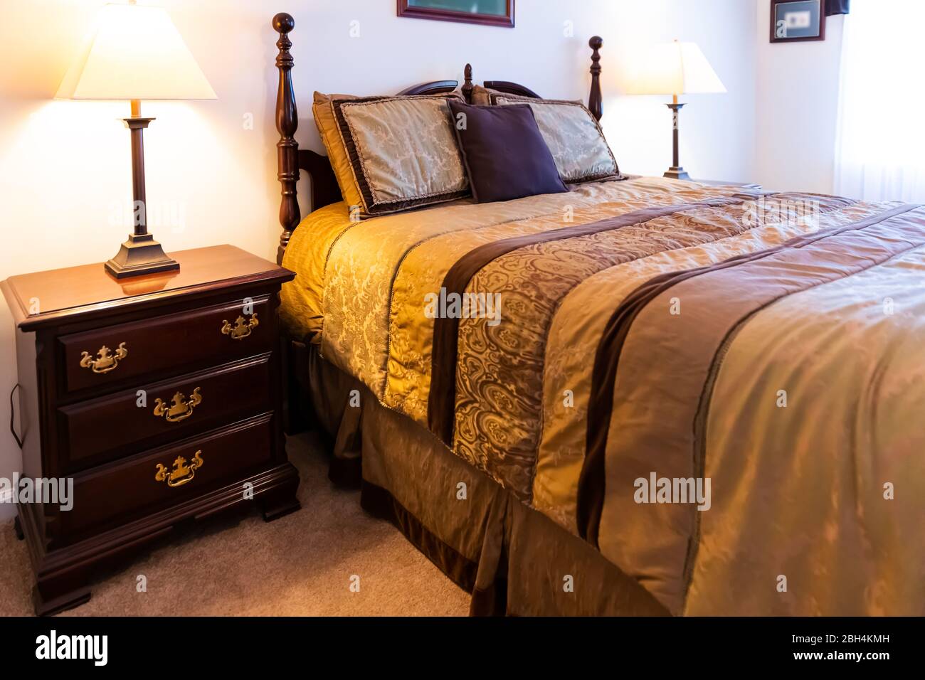 https://c8.alamy.com/comp/2BH4KMH/closeup-of-new-bed-comforter-with-decorative-pillows-and-wooden-headboard-in-bedroom-in-staging-home-house-or-apartment-country-style-2BH4KMH.jpg