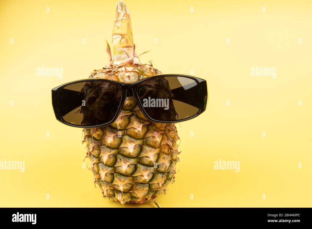 Pineapple wearing sunglasses on a yellow background Stock Photo Alamy