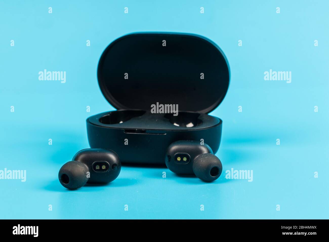Wireless bluetooth headphones isolated on blue background Stock Photo
