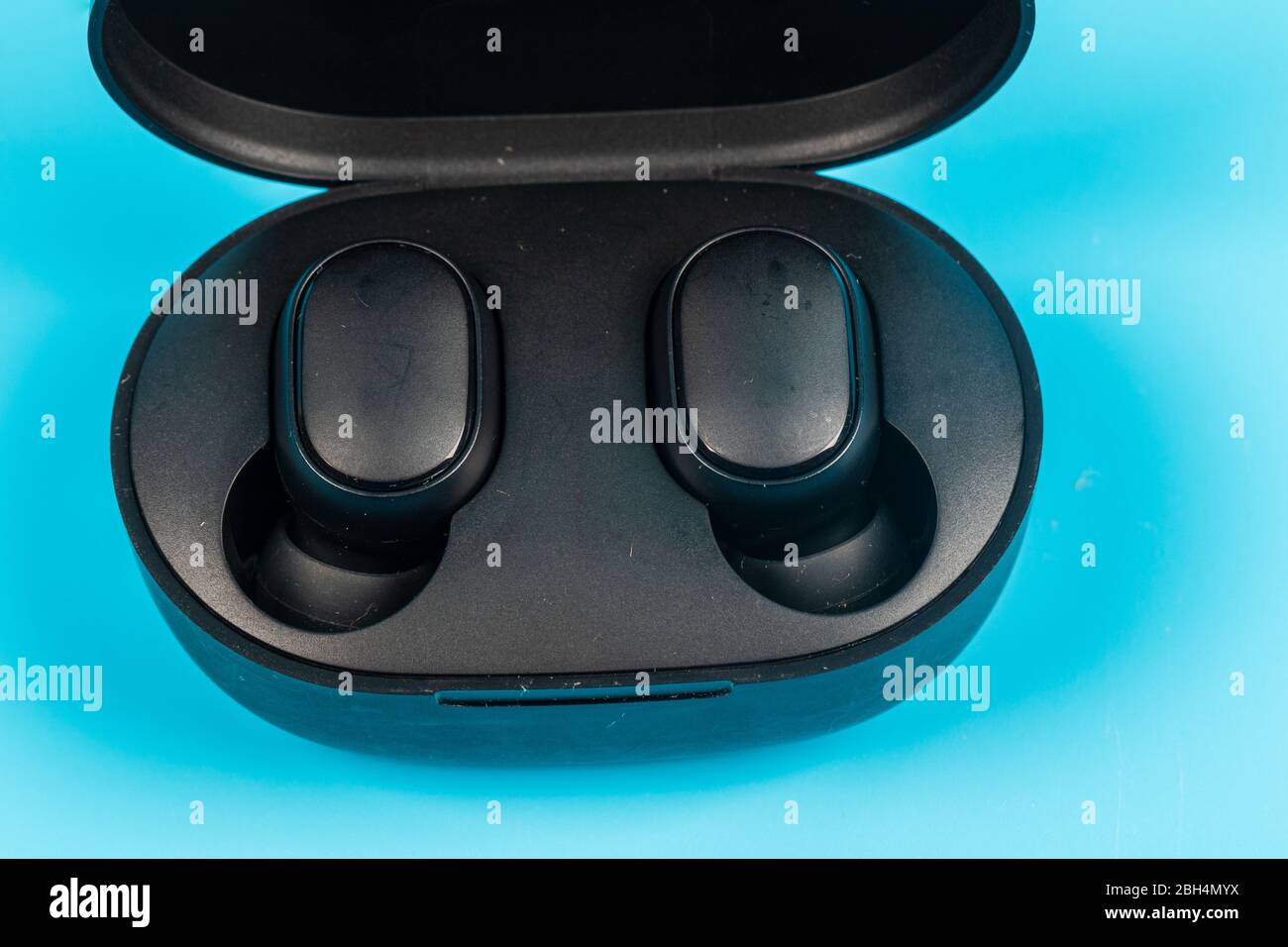Wireless bluetooth headphones isolated on blue background Stock Photo