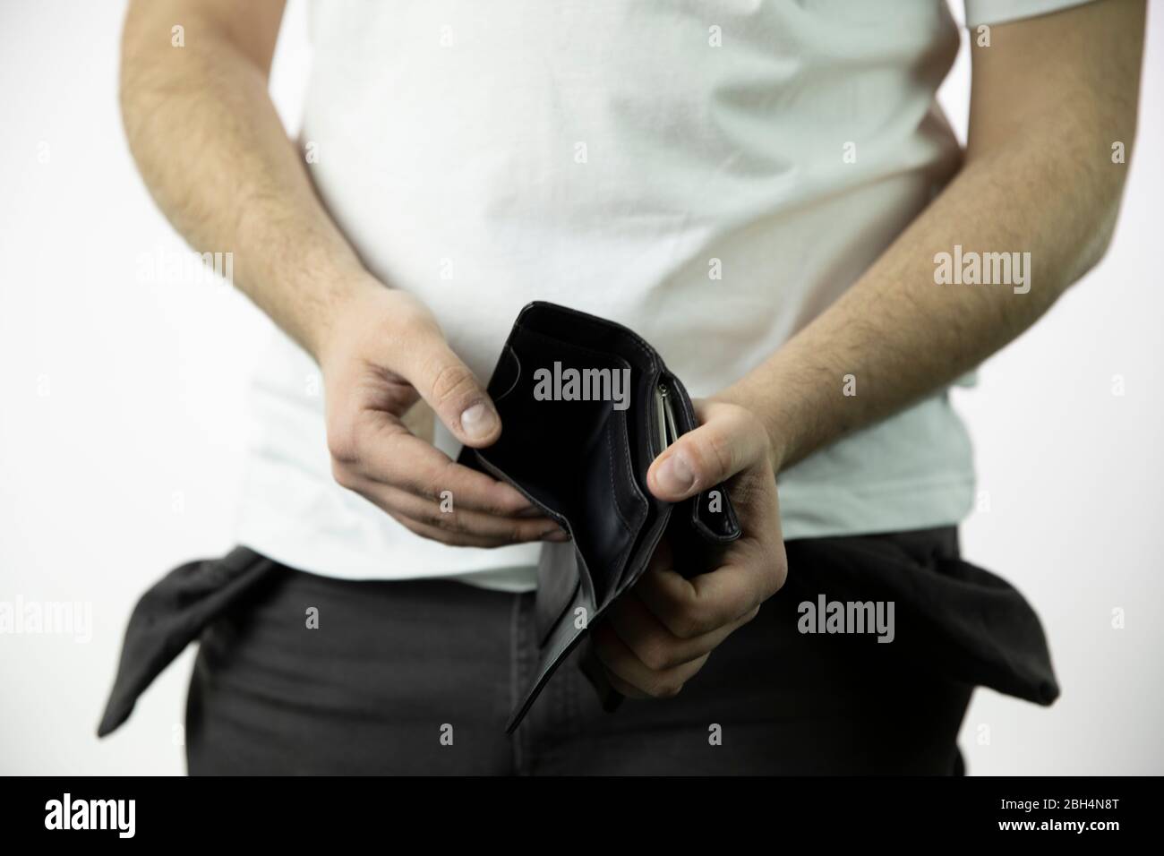men's hands show empty open wallet and empty pants pockets turned