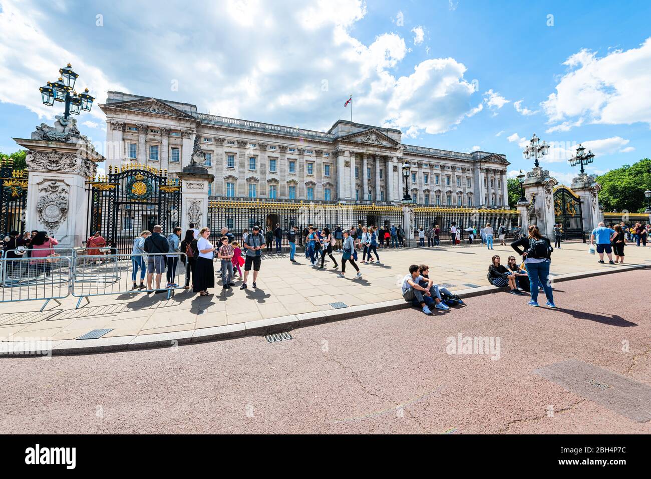 London, UK - June 21, 2018: Gold gate fence entrance at Buckingham Palace with many people tourists walking on street road sightseeing in United Kingd Stock Photo