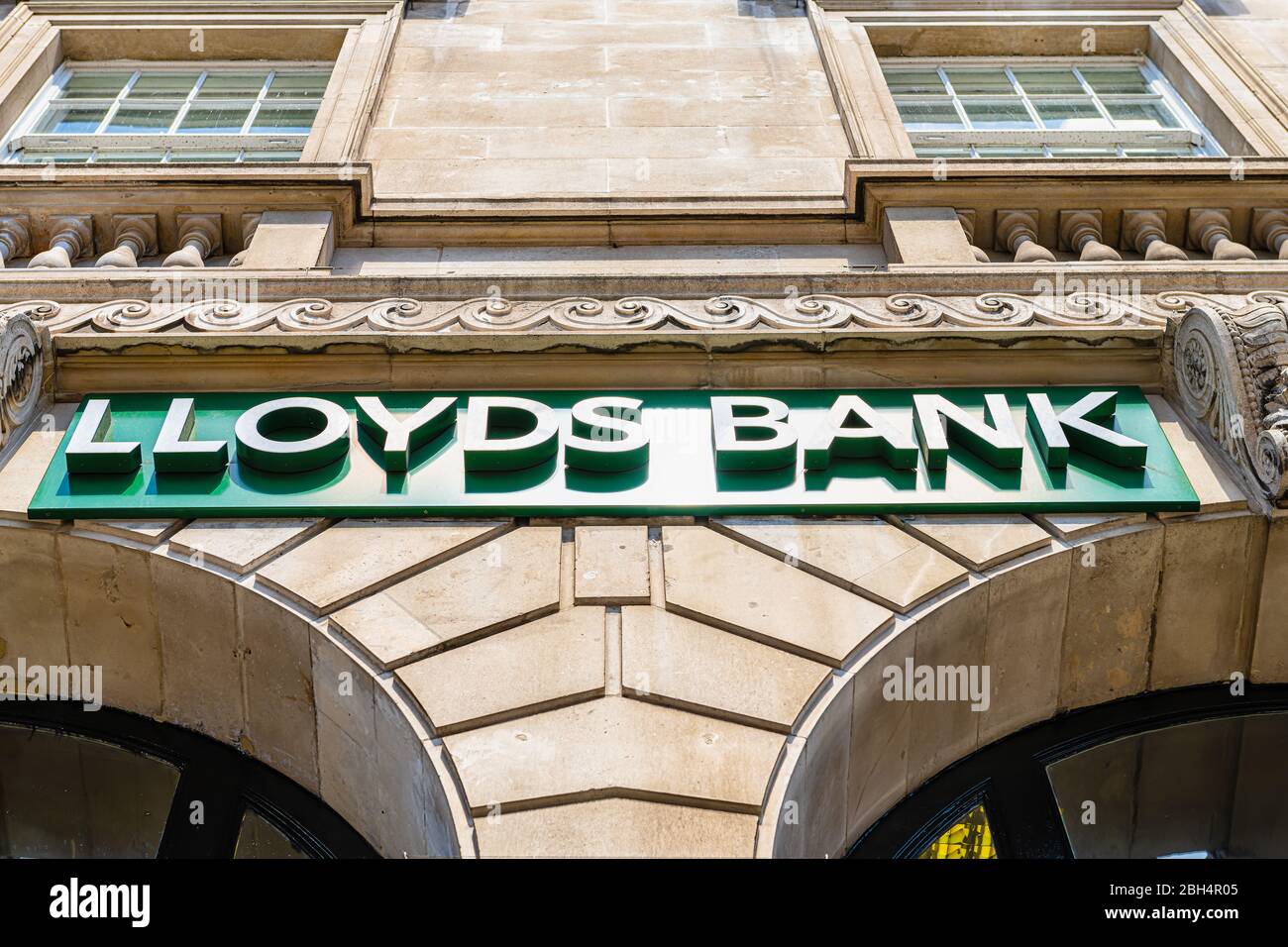 London, UK - June 22, 2018: Low angle looking up view on Lloyds Bank sign on branch office in city with historic architecture Stock Photo