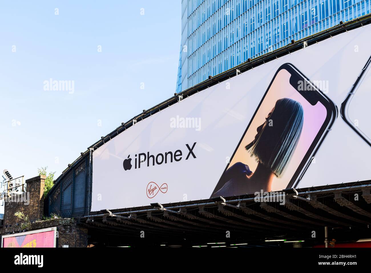 London, UK - June 22, 2018: Advertisement Billboard sign for iPhone X and Virgin Media and background of modern skyscraper building Stock Photo