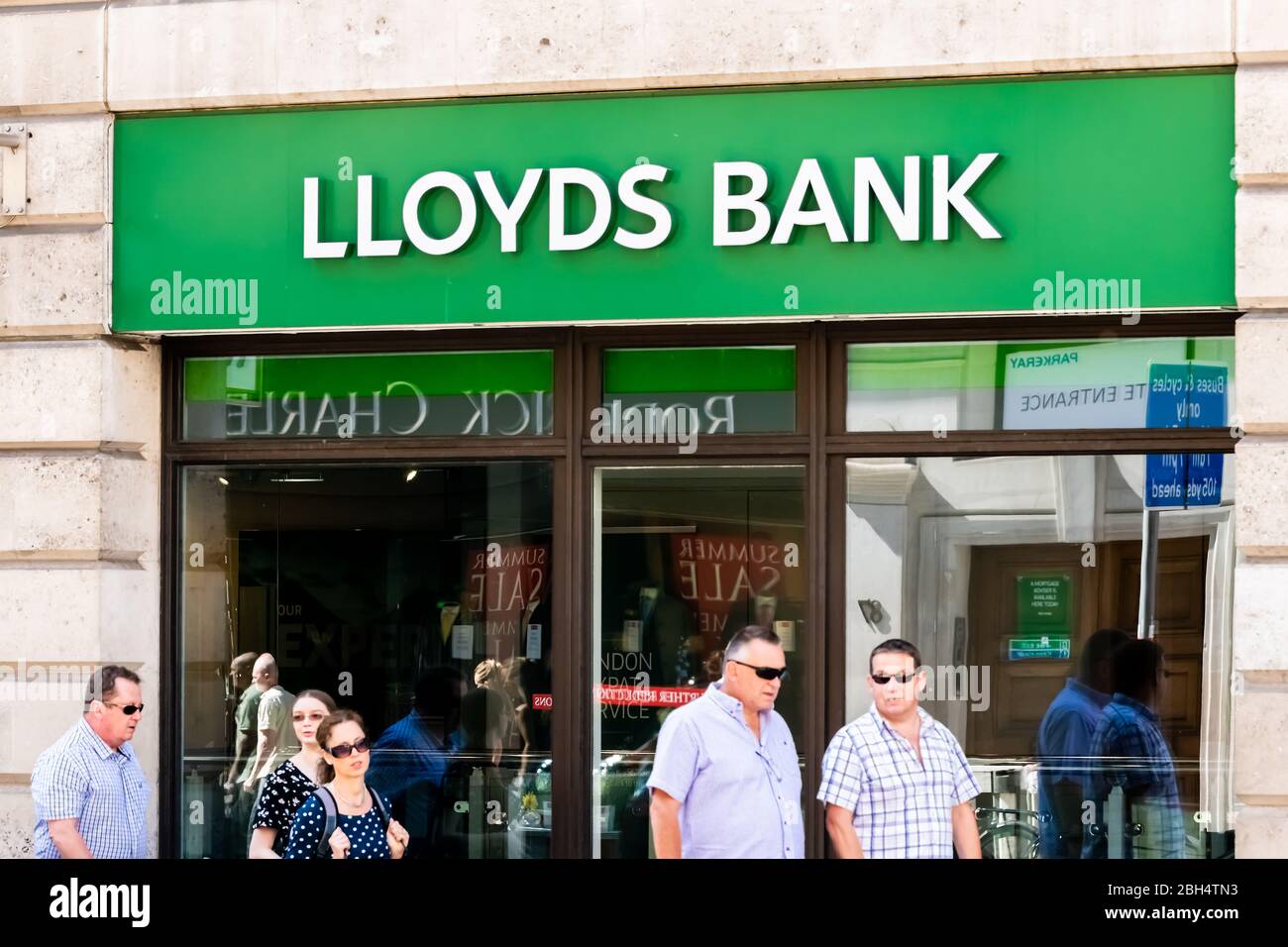 London, UK - June 26, 2018: Lloyds Bank sign on branch office in city downtown financial district with candid people walking on sidewalk Stock Photo