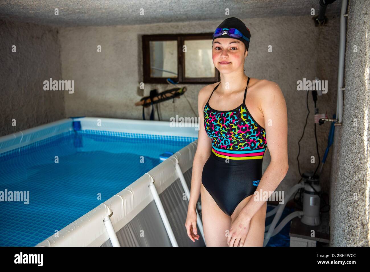 Slovenian swimmer, Katja Fain poses for a photo after training in a swimming pool in her garage.  Due to the Covid-19 pandemic public swimming pools and other sports facilities are closed. Stock Photo