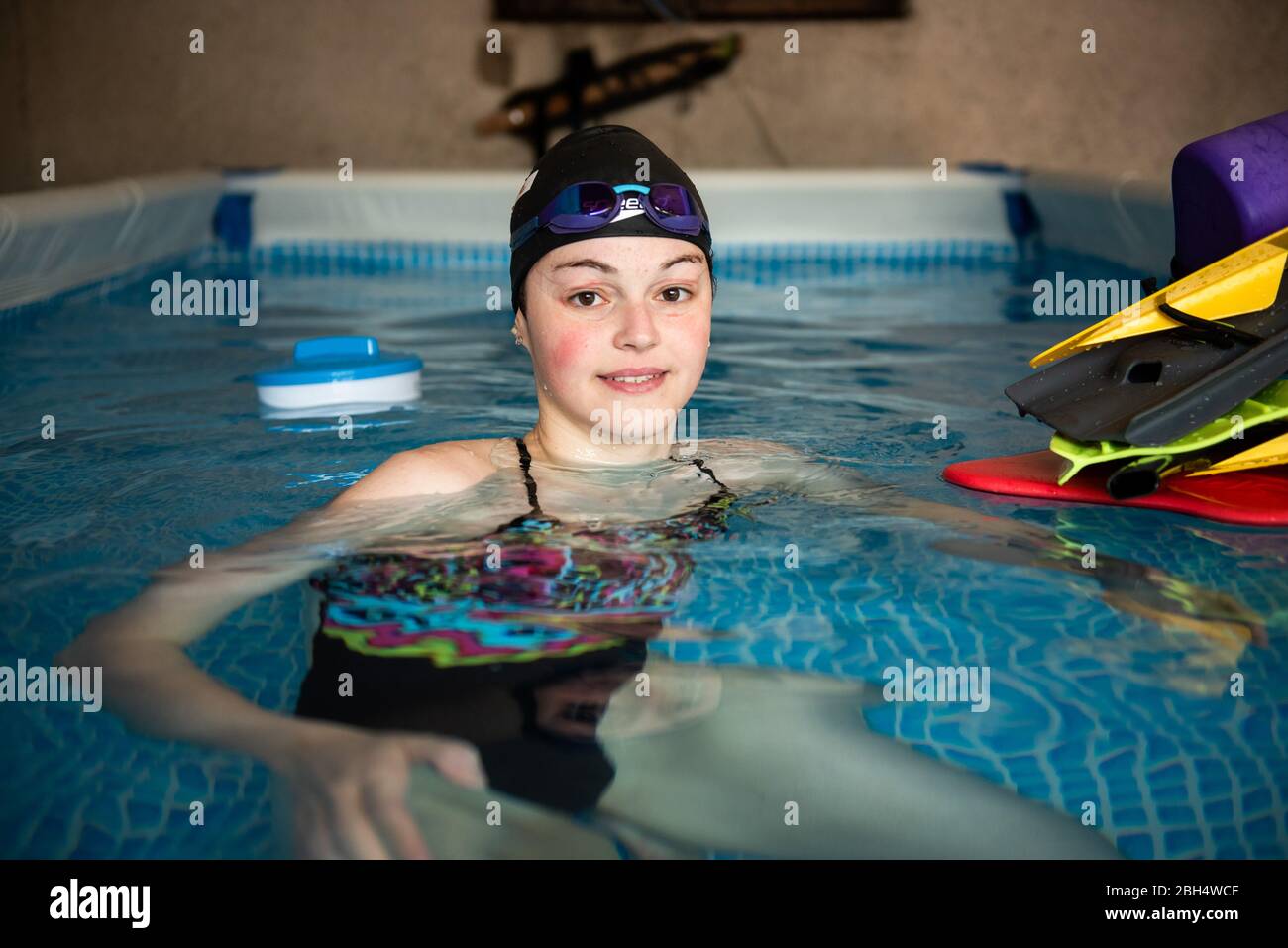 Slovenian swimmer, Katja Fain poses for a photo after training in a swimming pool in her garage.  Due to the Covid-19 pandemic public swimming pools and other sports facilities are closed. Stock Photo