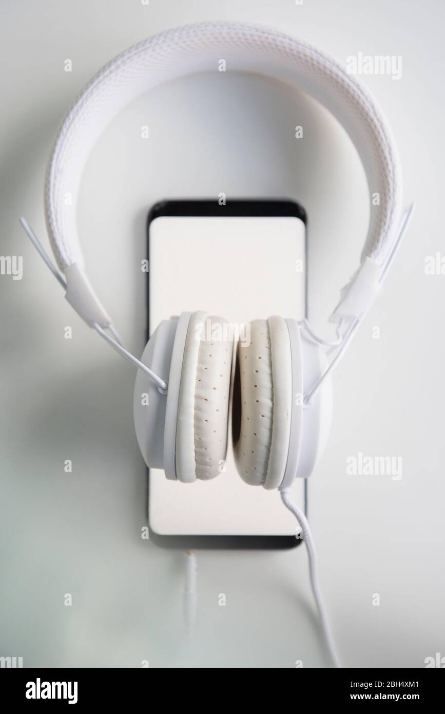 White headphones connected to smart phone Stock Photo Alamy