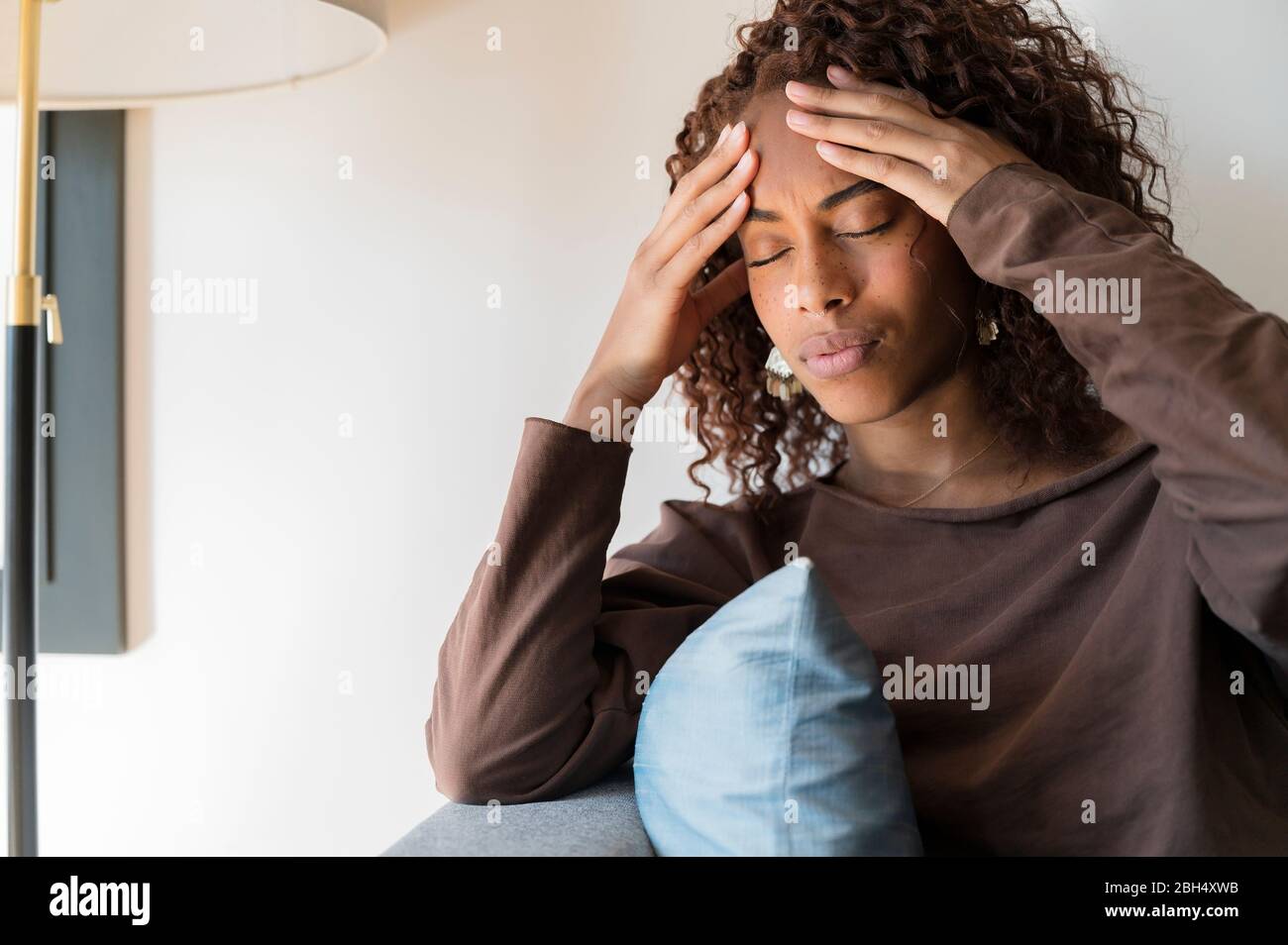 Woman with headache holding her head Stock Photo