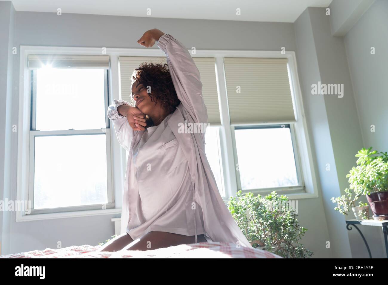 Woman stretching on bed Stock Photo