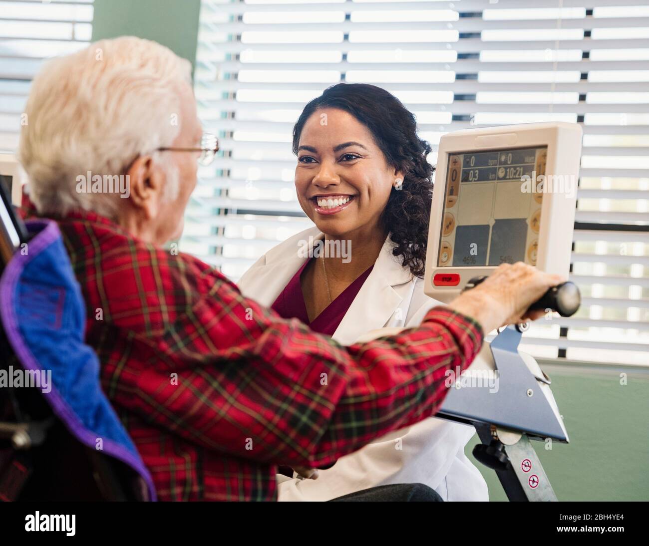 Smiling doctor and senior man by machine monitor Stock Photo