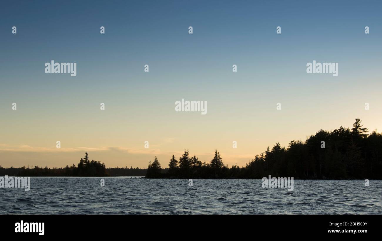 Silhouette of trees and lake at sunset Stock Photo - Alamy