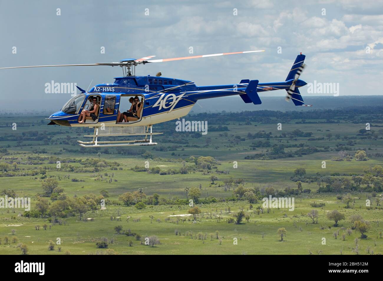 Tourists in Longranger helicopter on flight over Okavango Delta, Botswana, Africa- aerial Stock Photo