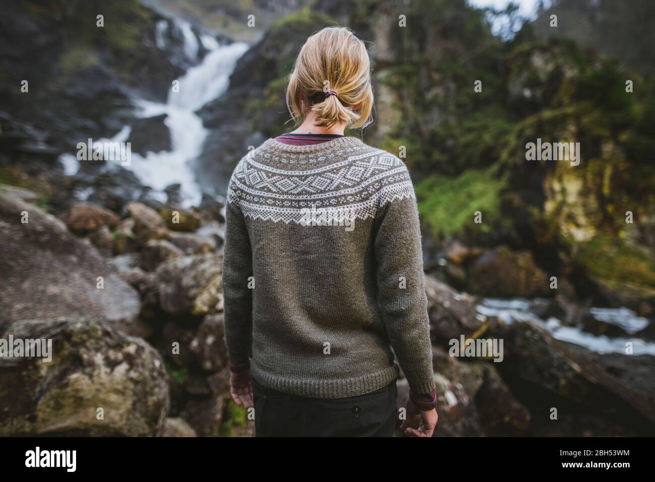 Woman wearing sweater by Latefossen waterfall in Vestland, Norway Stock Photo
