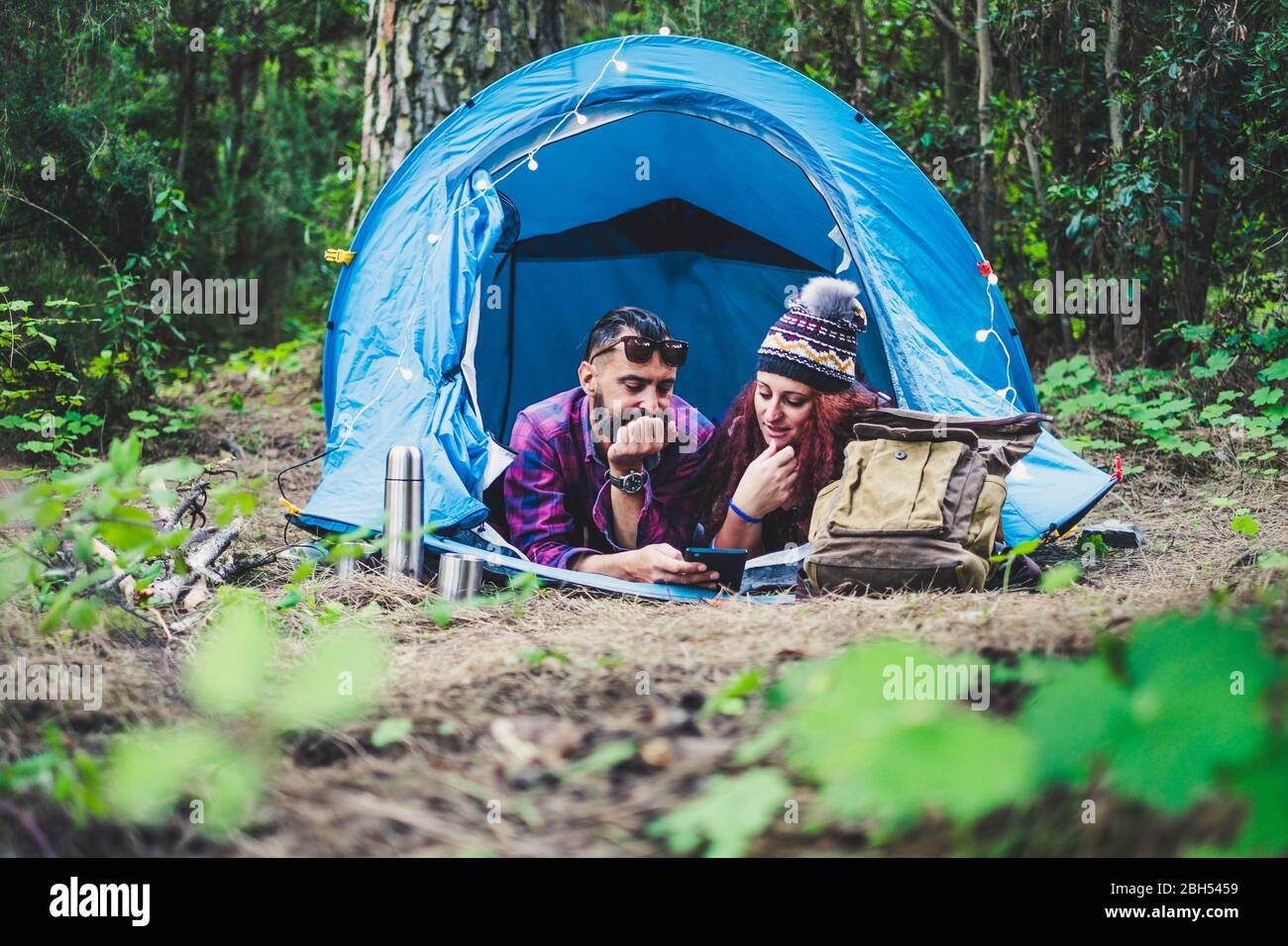 Couple lying in tent using tablet Stock Photo