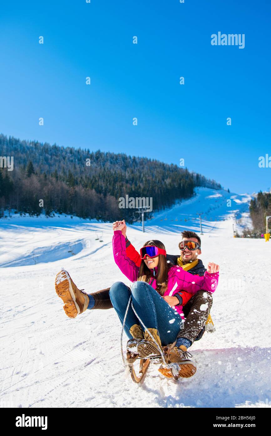 Young Happy Couple On Sledge Having Fun Stock Photo