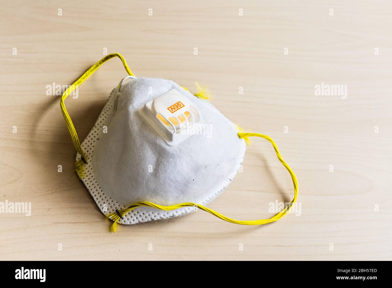 Used N95 respiratory mask discarded on a table; concept for the current PPE shortage in the battle against COVID-19 Stock Photo