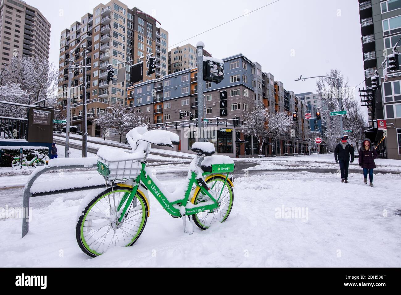 A Lime Bike sits unused in the snow in Seattle, WA, USA Stock Photo