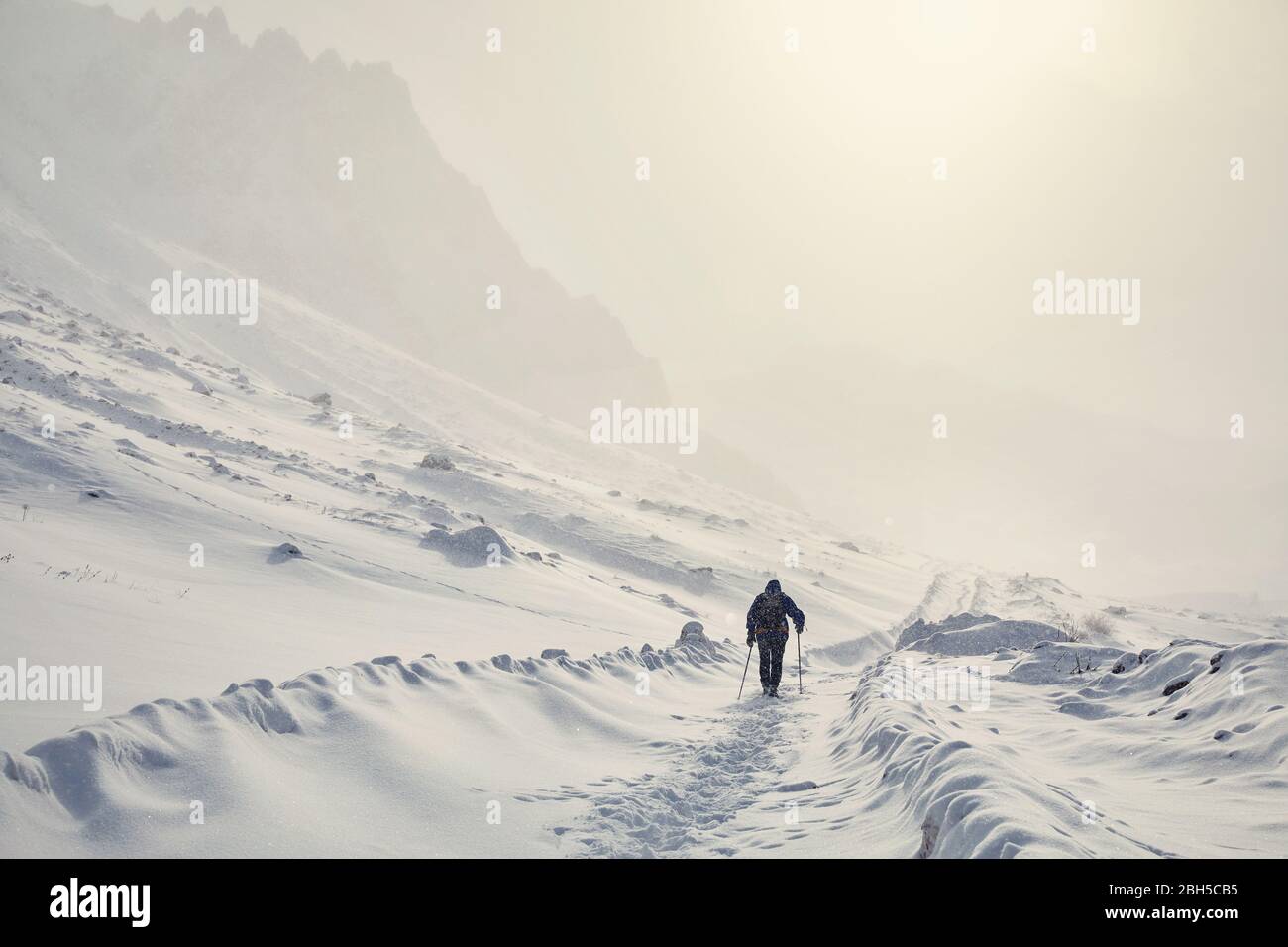 Tourist on the snow road in the beautiful mountains at winter Stock Photo