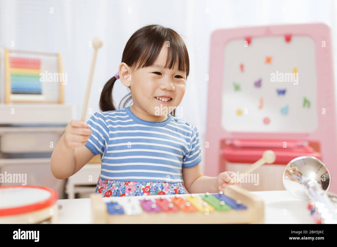 toddler girl play xylophone at home for homeschooling Stock Photo Alamy