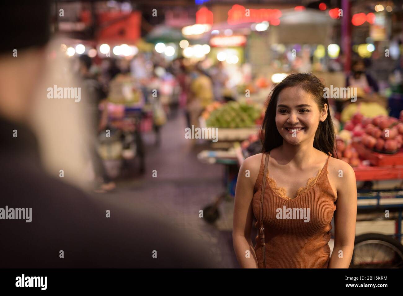Friendly young Asian woman helping tourist man with directions in ...