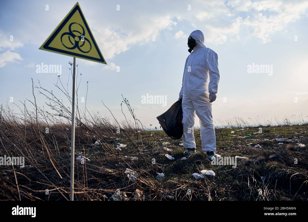 Garbege Protection Mask Environmentalist in protective suit and gas mask holding garbage bag ...
