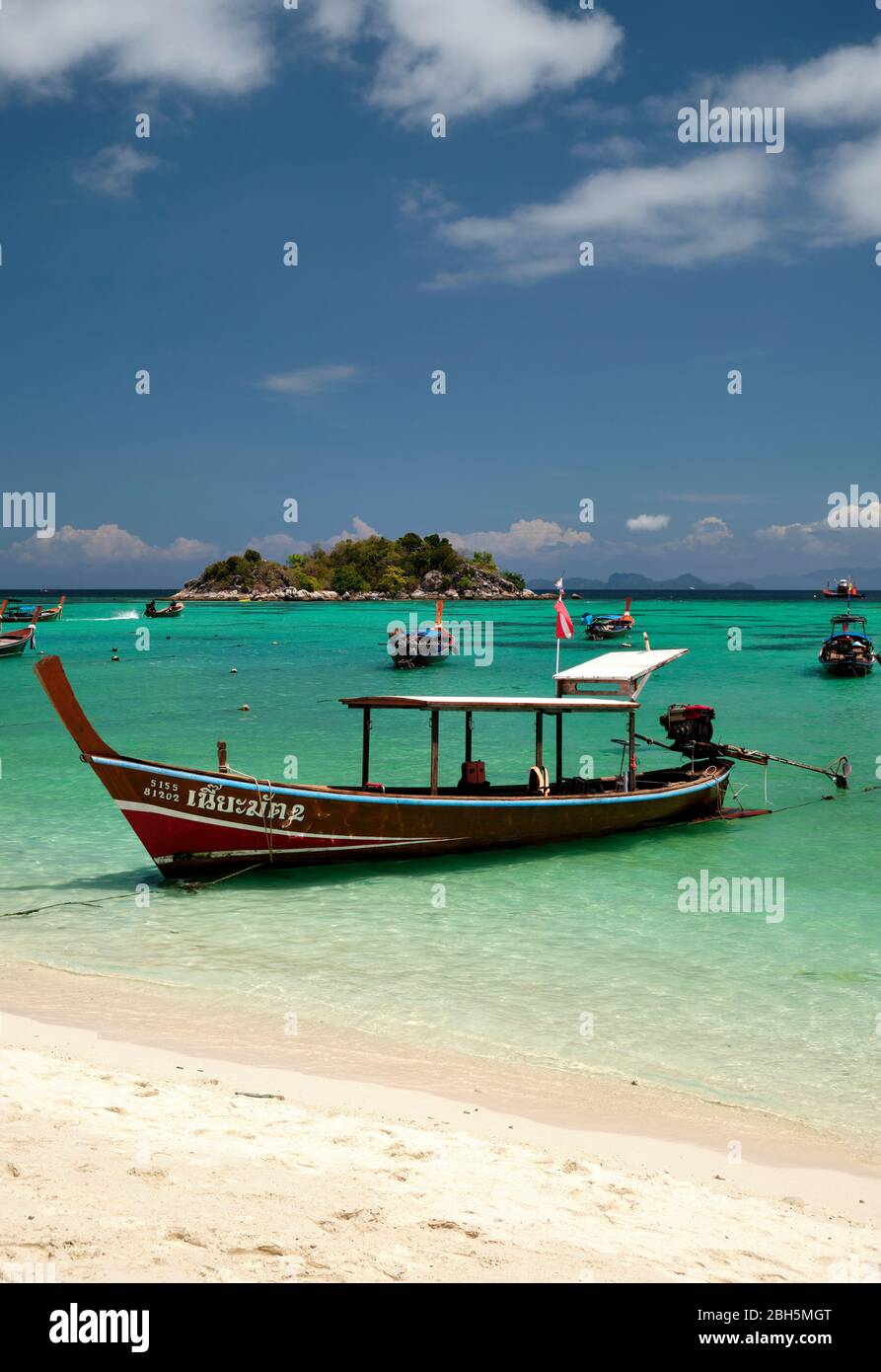 Taxi boat on sunrise beach thailand asia, with clear blue water and blue sky, vertical format Stock Photo