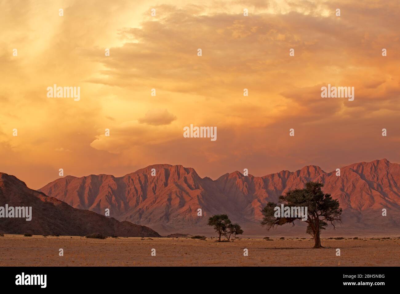 Namib desert landscape at sunset with rugged mountains and dramatic clouds, Namibia Stock Photo
