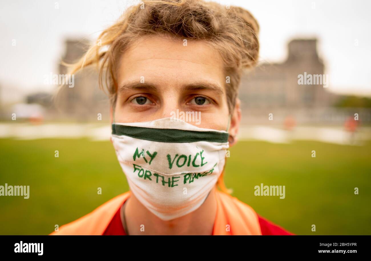 Berlin, Germany. 24th Apr, 2020. 'My voice for the planet' is on the mouth-and-nose guard of an activist from Fridays for Future at the beginning of the alternative climate strike on the Reichstag meadow. Because of the continuing spread of the corona virus, the climate strike is being digitally distributed on the Internet and strikers can participate via the website at www.fridaysforfuture.de/netzstreikfursklima. Credit: Kay Nietfeld/dpa/Alamy Live News Stock Photo