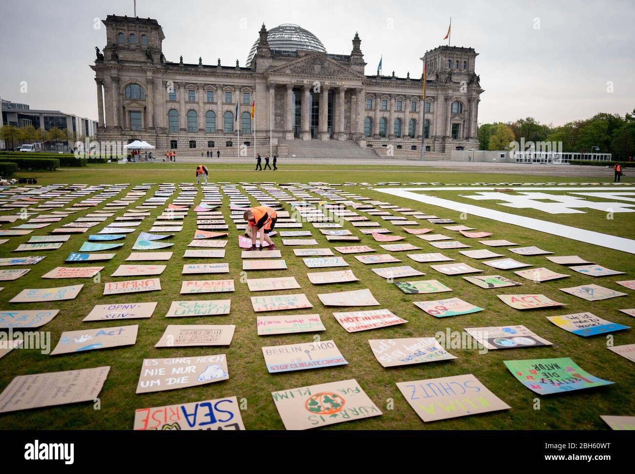 Berlin, Germany. 24th Apr, 2020. Activists of Fridays for Future put out protest posters for climate protection on the Reichstag meadow at the beginning of the alternative climate strike in the morning. Because of the continuing spread of the corona virus, the climate strike will be digitally distributed on the Internet and strikers can participate via the website at www.fridaysforfuture.de/netzstreikfursklima. Credit: Kay Nietfeld/dpa/Alamy Live News Stock Photo