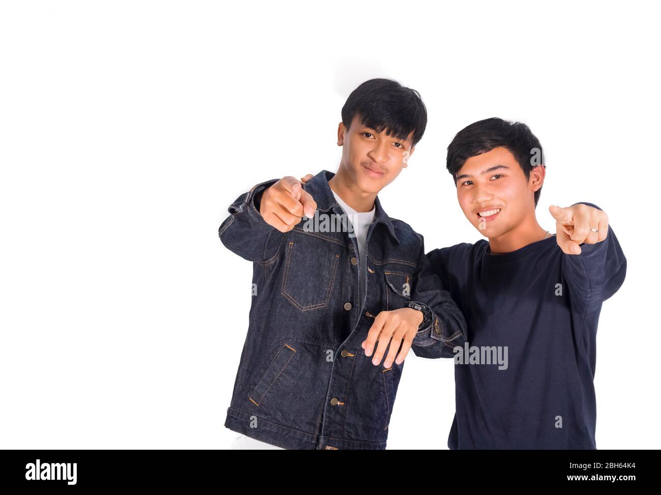 Two Asian boys are pointing to the camera white background. Stock Photo
