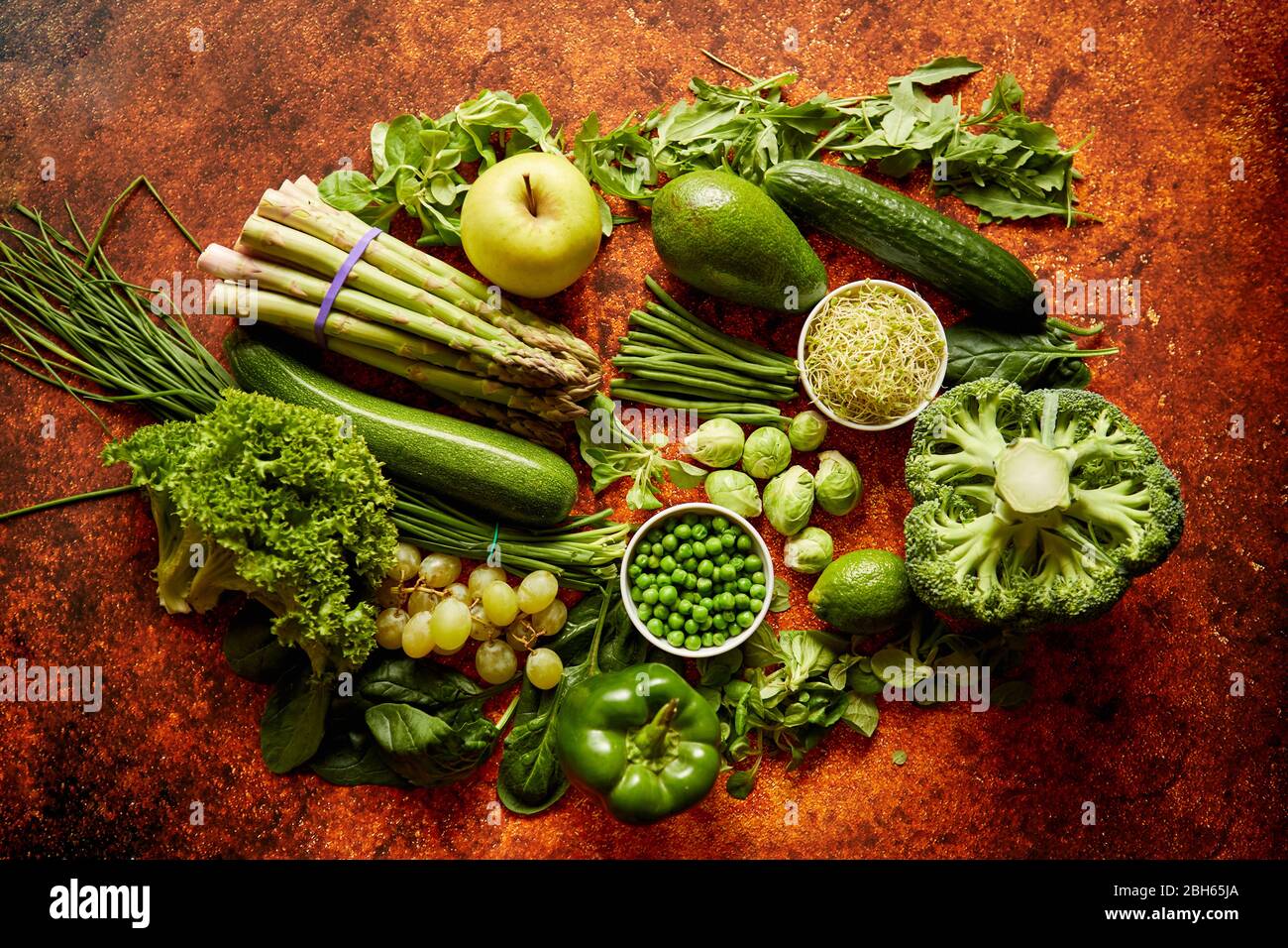 Fresh green vegetables and fruits assortment placed on a rusty metal ...