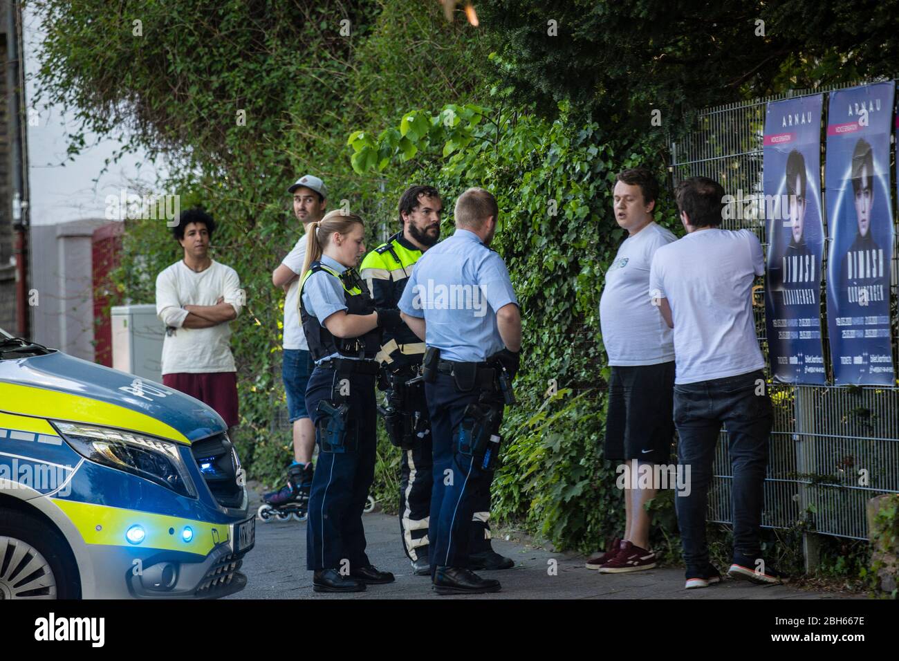 Zwei Polizeibeamte einer Funkstreife sowie ein Motorradpolizist überprüfen zwei junge Männer am Friedhof in Düsseldorf-Heerdt. Persönlichkeitsrechte b Stock Photo