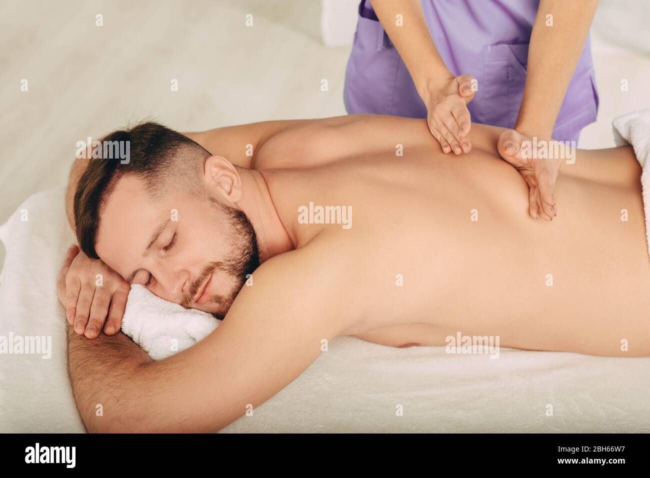 Handsome man enjoying back massage at spa resort Stock Photo