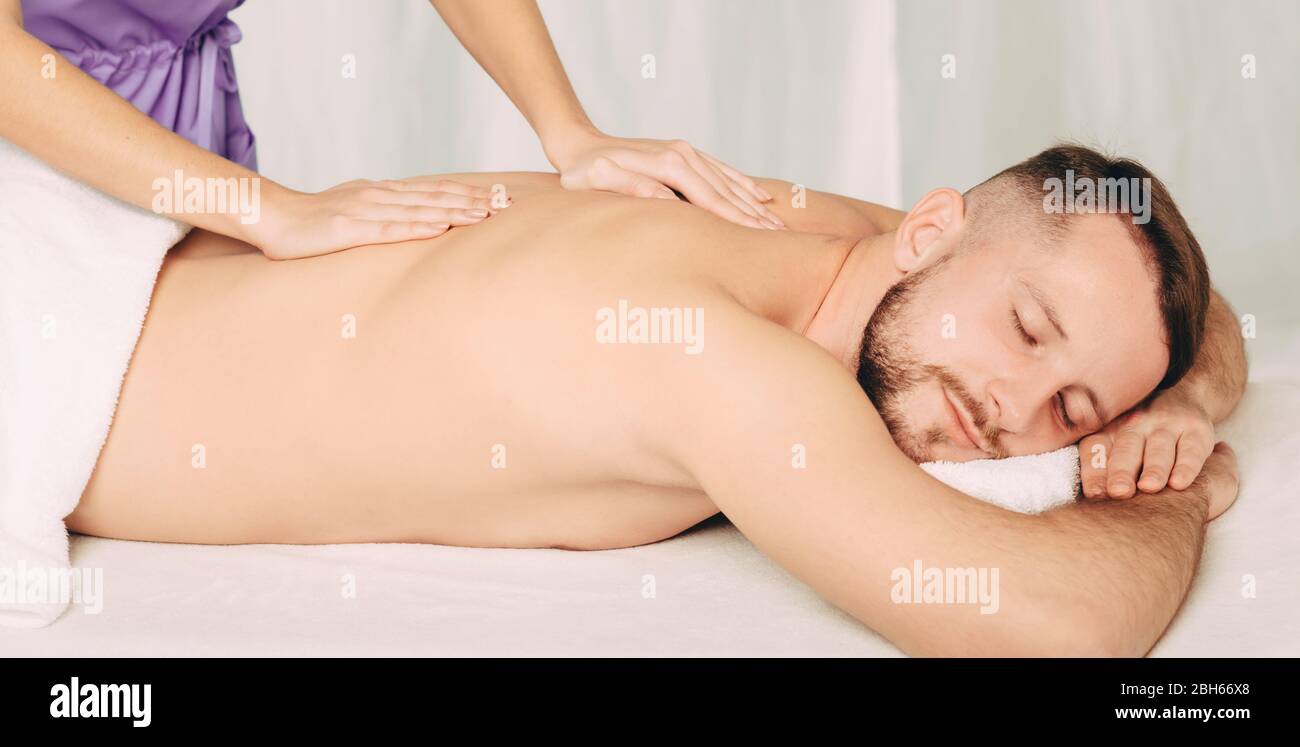 Handsome man enjoying back massage at spa resort Stock Photo