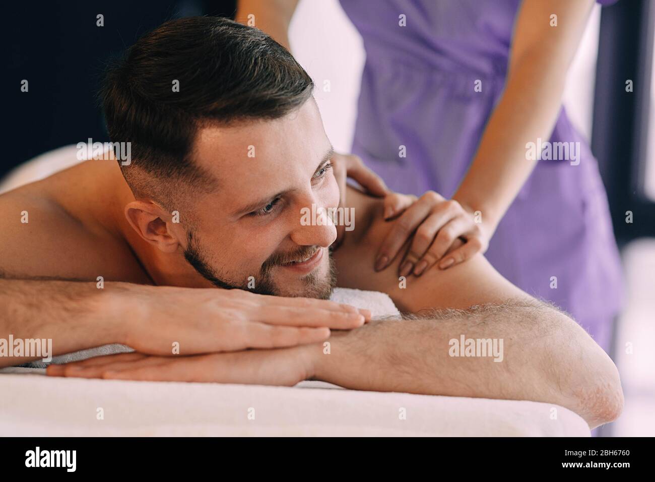 Happy man relaxing in the spa, and enjoying back massage. Man at Wellness resort Stock Photo