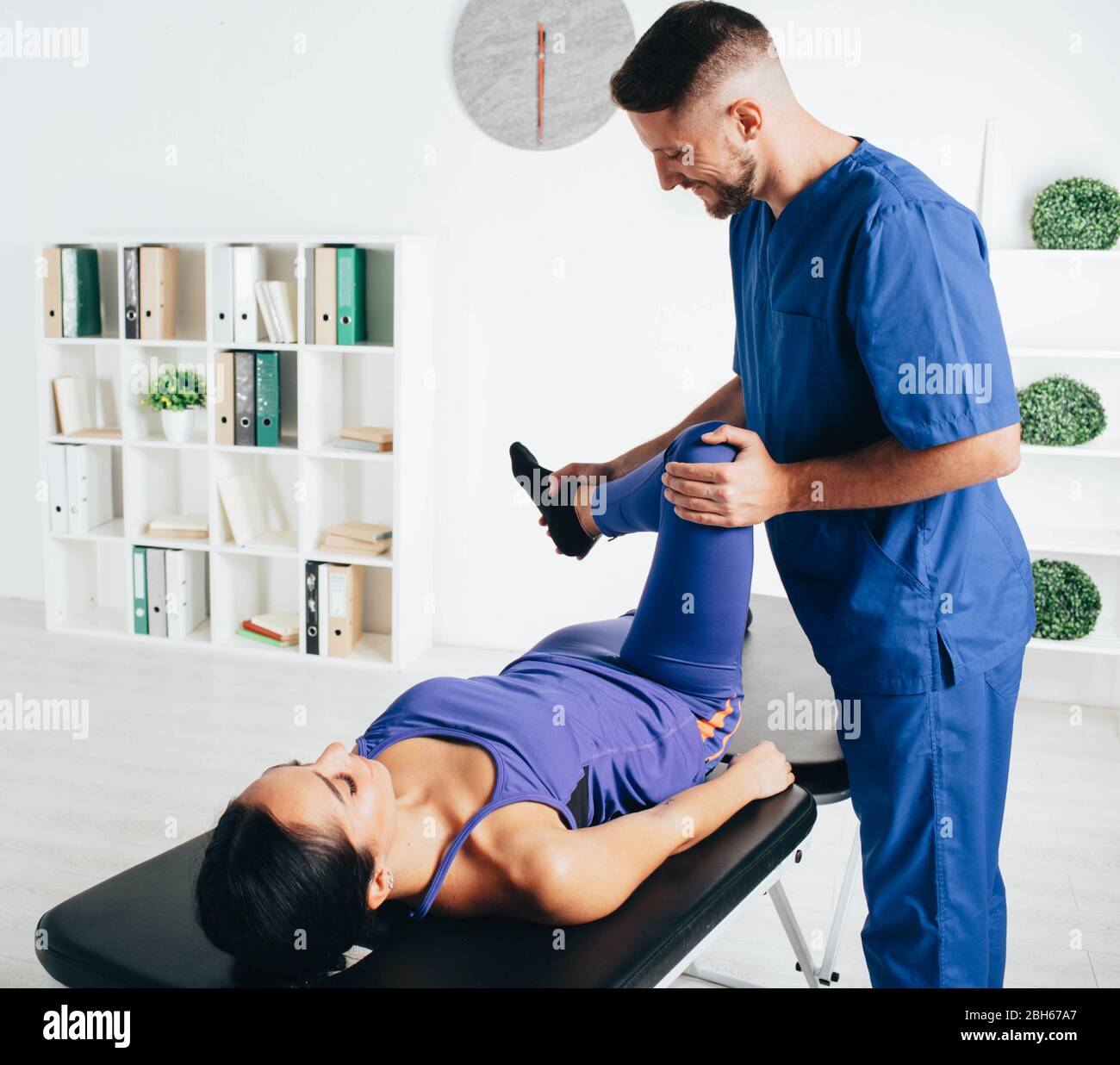 woman visiting her physiotherapist. patient doing exercise for treatment joint. Stock Photo