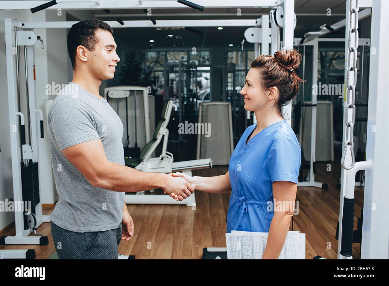 Healthy athlete says thanks to the physiotherapist for the treatment. Rehabilitation center helps athletes recover from injuries Stock Photo
