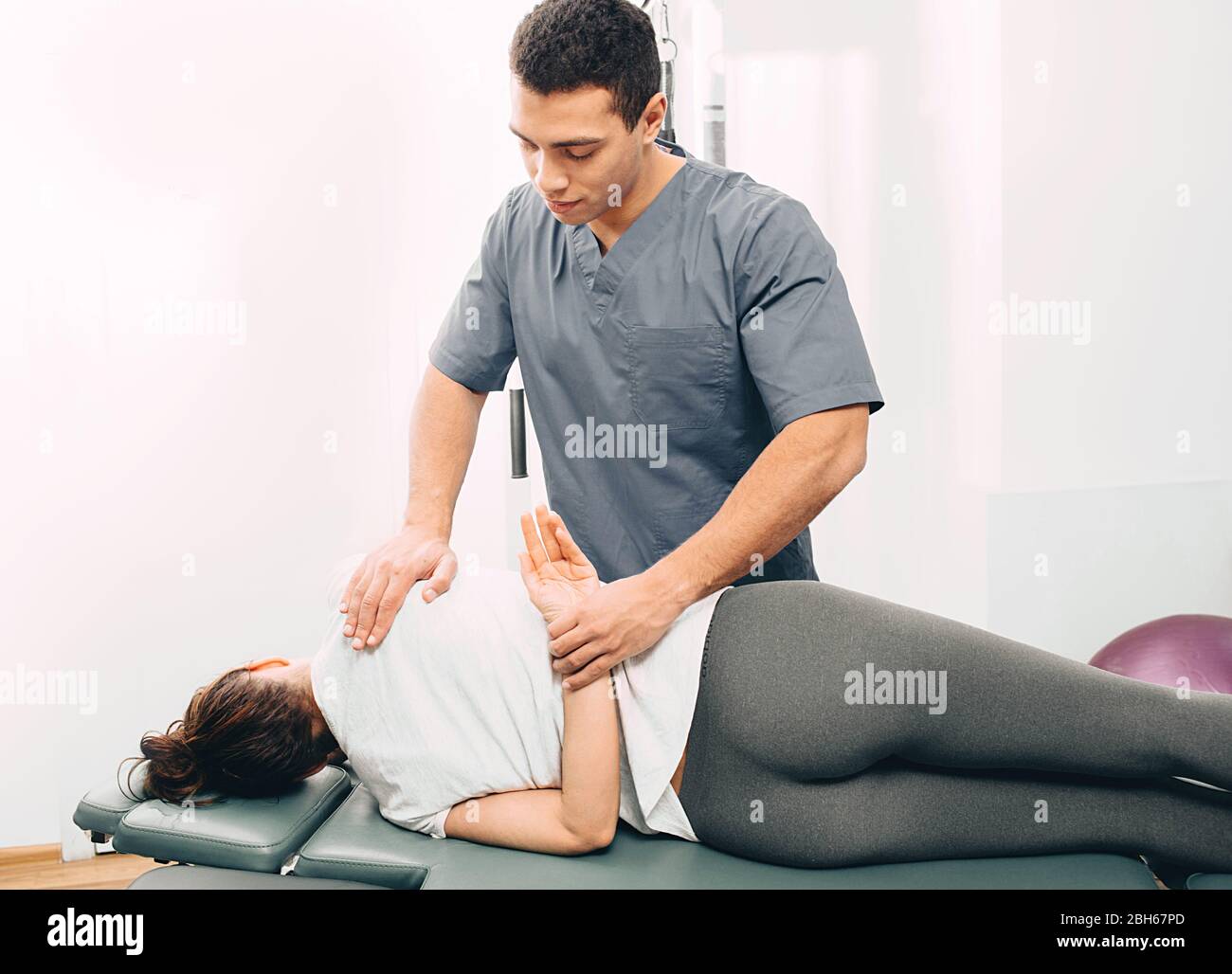 Physiotherapist doing exercises to treat the joints of the patient. Rehabilitation in the clinic Stock Photo