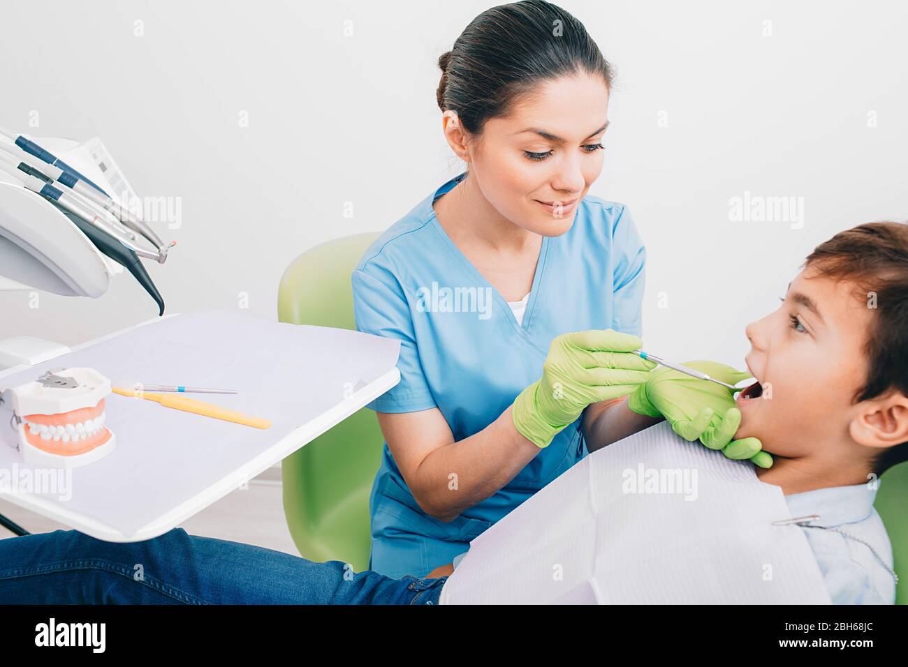 Dentist doing dental teeth exam to a little boy at medical office Stock Photo